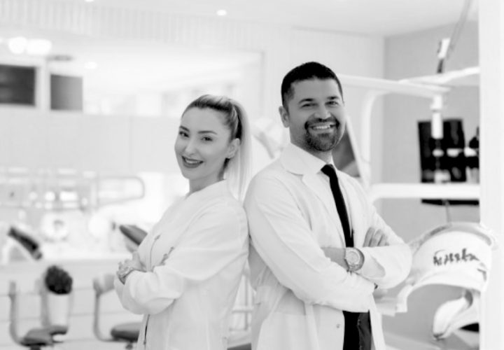 Two dentists smiling confidently in modern dental clinic