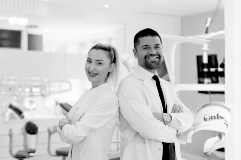 Two dentists smiling confidently in modern dental clinic